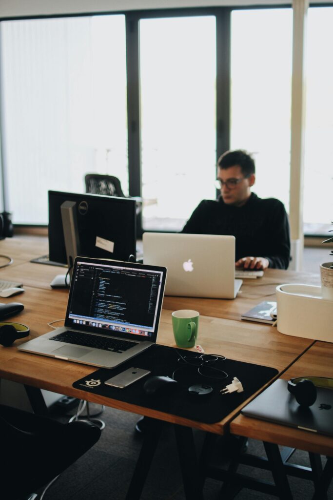 pexels-photo-2102416-2102416-1 A web developer working on code in a modern office setting with multiple devices.